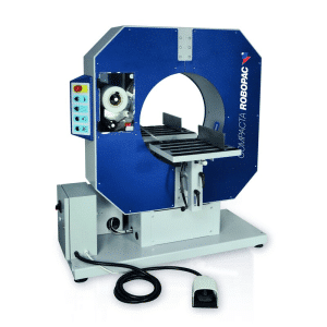 Industrial packaging machine (Robopac) with blue enclosure, circular load chamber, conveyor table, control panel, and foot pedal nearby.