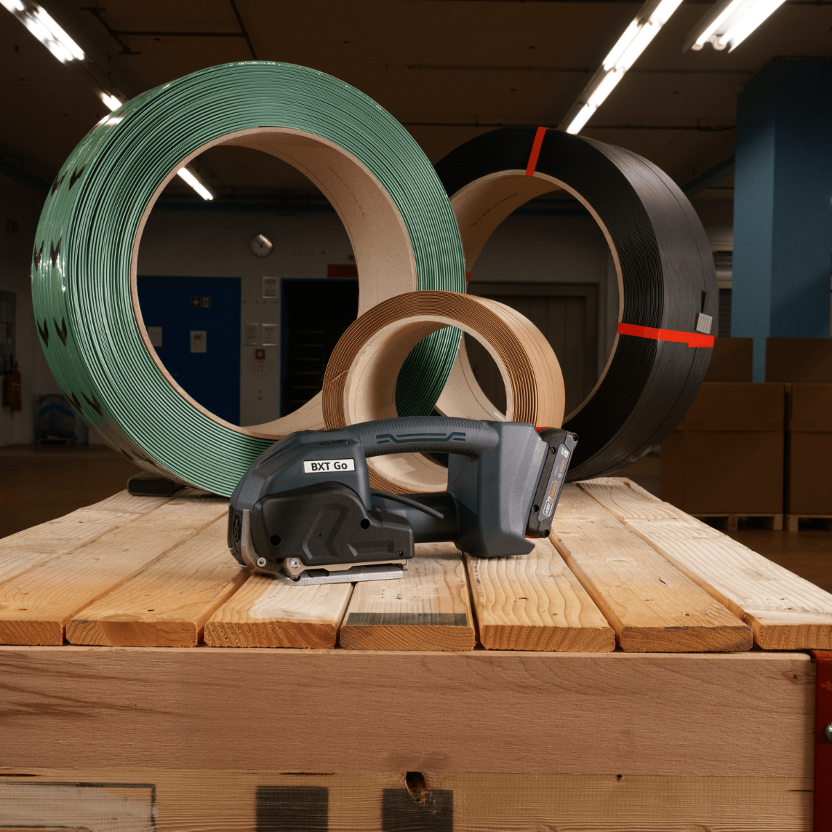 BXT Go Battery Powered Strapping Tool with Strapping Rolls | Maxpack BXT Go battery powered strapping tool displayed with green, black and paper strapping rolls.